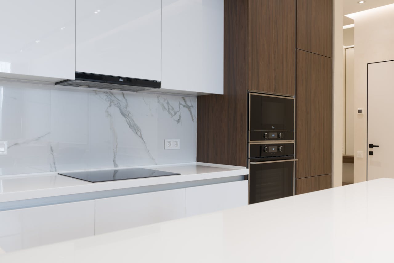 Contemporary clean kitchen with sleek appliances and wooden cabinetry, perfect for a new home.